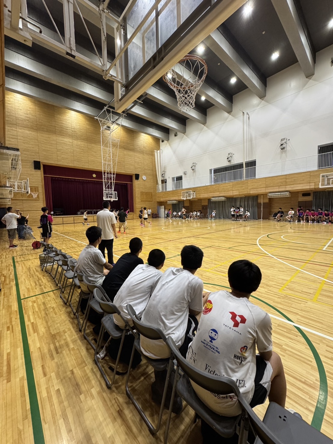 試合会場でコートを見つめるTeam Hustleの選手たち